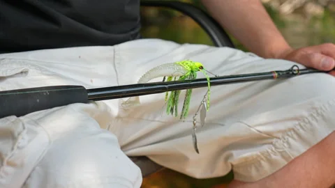 Man sitting with casting rod and attached perch spinner spoon blade with pl.. Stock Footage 327669320