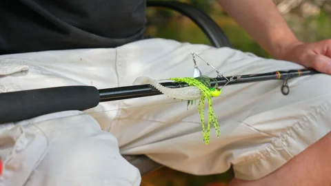 Man sitting with casting rod and attached perch spinner spoon blade with pl.. Stock Footage 327669322