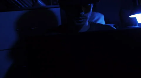 Man sitting on chair in front of computer monitor seriously Stock Footage 64978733