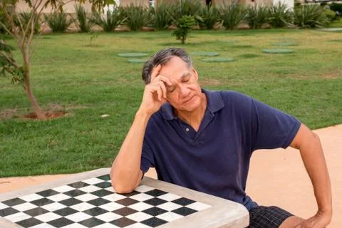 Man Sitting at a Checkerboard Table Stock Photos