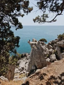 Man sitting on the cliff edge Stock Photos