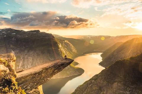 Man sitting on the cliff of Trolltunga Stock Photos