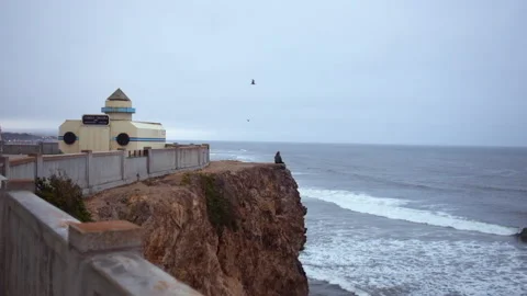 Man sitting on cliffs in san francisco ocean beach Stock Footage