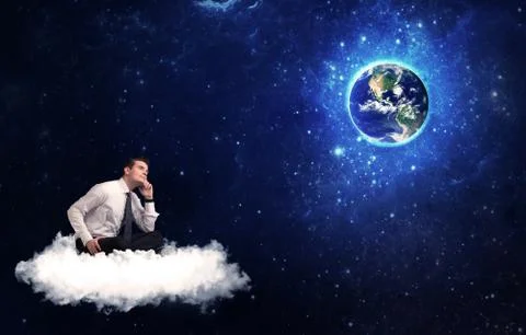 Man sitting on cloud looking at planet earth Foto stock