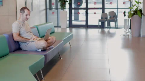 Man sitting on the coach smiling while using computer. Stock Footage 236176012
