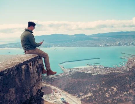 Man sitting with compass over the bay Stock Photos