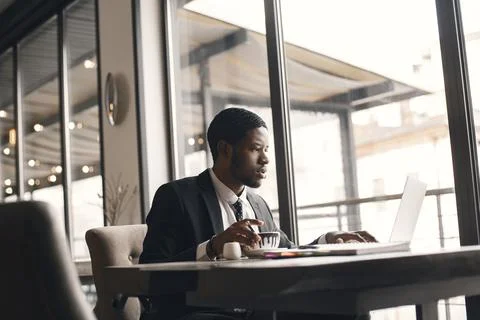 Man sitting at the computer and drinking coffee Stock Photos