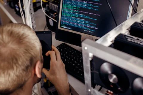 A man is sitting at computer devices Stock Photos
