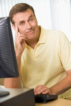 Man sitting at a computer terminal bored (high key) Stock Photos
