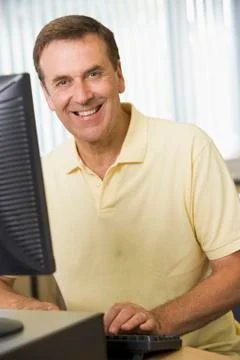 Man sitting at a computer terminal typing (high key) Stock Photos