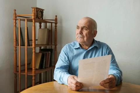 Man sitting contemplating a written document Stock-Fotos