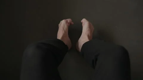 Man sitting on a couch and making feet streych excercise Stock Footage 155224204