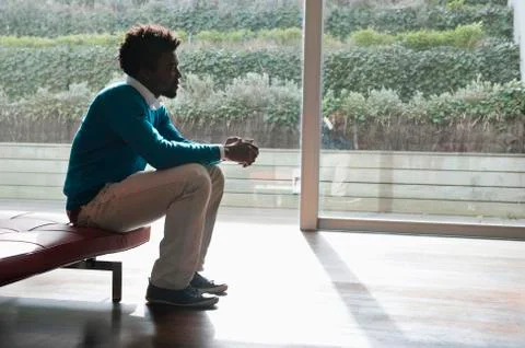 Man sitting on a couch and thinking Stock Photos