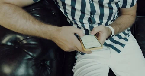 A man sitting on the couch and using the phone Stock Footage 140249252