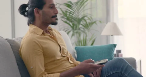 Man sitting on the couch and watching TV Video stock 157679383