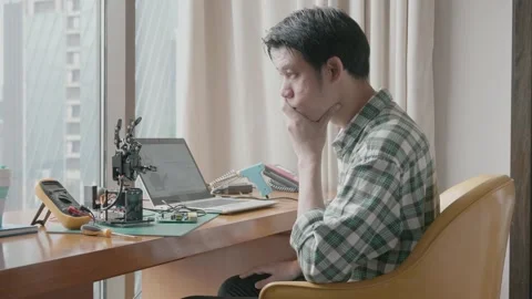 A man is sitting on a couch and working on a project Stock Footage 314004015