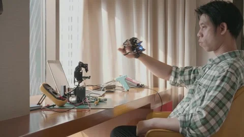 A man is sitting on a couch and working on a Robot project Stock Footage 314593640