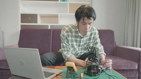 A man is sitting on a couch and working on a project Stock Footage 314901958