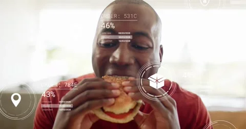 Man sitting couch bringing burger close and taking bite, delivery HUD tracking Stock Footage 320955562