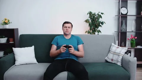 A man sitting on the couch in front of the TV is focused Video stock 147670775
