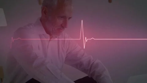 Man sitting on couch leaning to tablet, checking heart data while pink ECG line Stock Footage 329750427