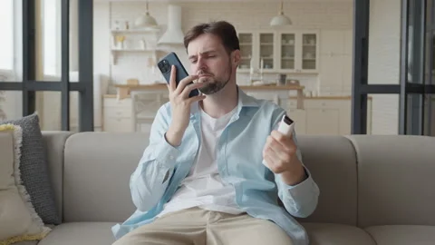 Man Sitting On Couch, Looking At Product Tube With Doubtful Facial Expression Video stock 306696874