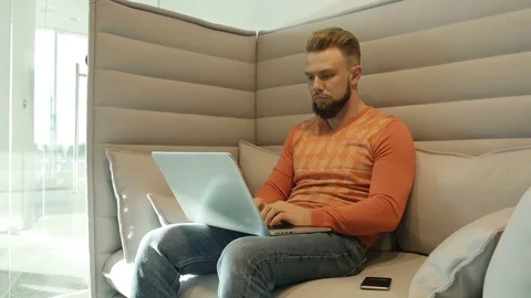 Man sitting on couch talking on phone 库存影片 77283581