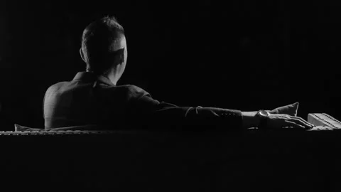 A man is sitting on the couch in the twilight, the back view, fashion Video stock 92486880