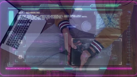 Man sitting cross-legged at low table, tapping device as HUD appearing, scanning Stock Footage 334743639
