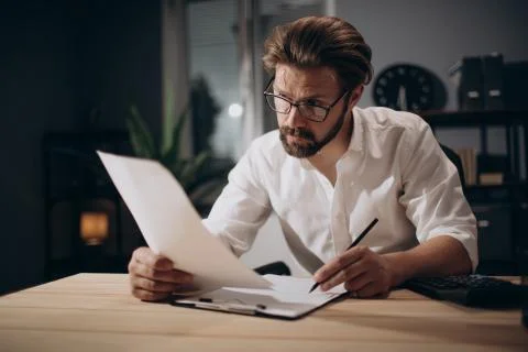Man sitting at dark office while counting financial data Stock Photos