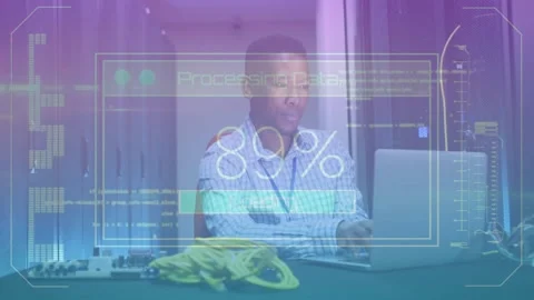 Man sitting at data center desk using laptop while processing data overlay Stock Footage 319572702