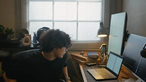 Man Sitting at Desk and Coding on Laptop in Home Office Setup Stock Footage 338425151
