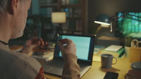 Man sitting at the desk and working on his laptop Stock Footage 306126396