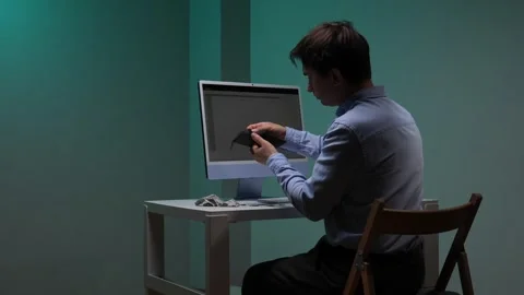 Man sitting at a desk checking his empty wallet, looking at a computer screen Stock Footage 345530508