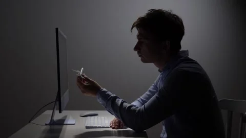 Man sitting at a desk with a computer, holding a small model airplane and Stock Footage 342671810