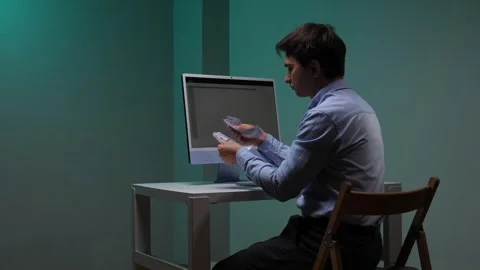 Man sitting at a desk. Counting a stack of banknotes. With a computer monitor Stock Footage 344605044