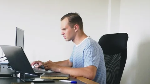 A man sitting at a desk at home, working at home computer and laptop. 스톡 동영상 106689247