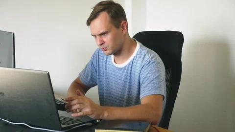 A man sitting at a desk at home, working at home computer and laptop. 스톡 동영상 106689428