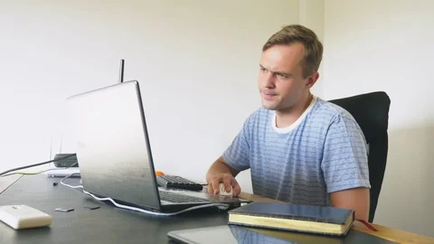 A man sitting at a desk at home, working at home computer and laptop. 스톡 동영상 106689501