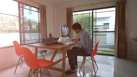 A man is sitting at a desk in a room with a computer monitor and a printer Stock Footage 318938102