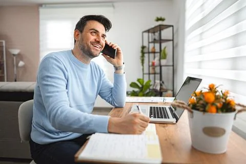 Man Sitting at Desk Talking on Cell Phone Stock Photos