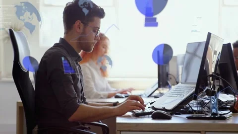 Man sitting desk typing and mousing, causing blue charts over screens and 스톡 동영상 334033983