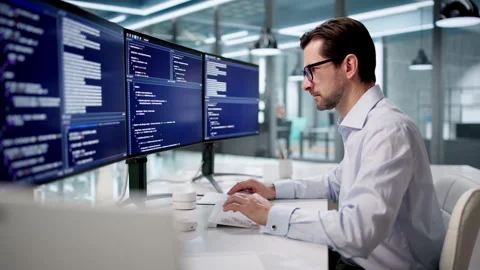 Man Sitting At Desk Typing Code On Computer Video stock 335457914