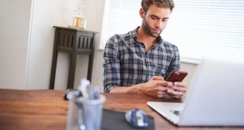 Man sitting at desk using cellphone Stock Photos