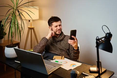 Man sitting at desk using smartphone in home office Stock Photos