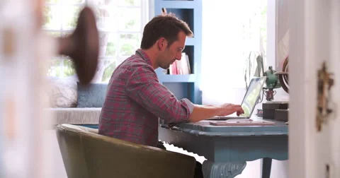 Man Sitting At Desk Working In Home Office Stock Footage