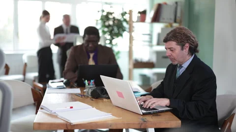 Man sitting at desk is working on laptop computer. Working day in office Stock Footage 343718933
