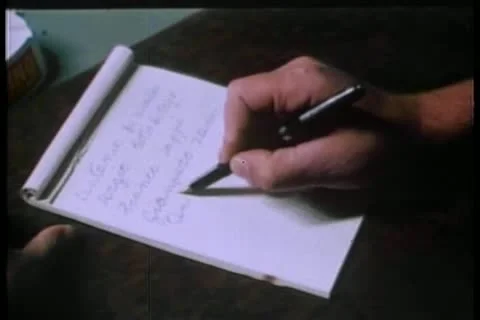 Man sitting at desk writing slowly on paper Stock Footage 11349853