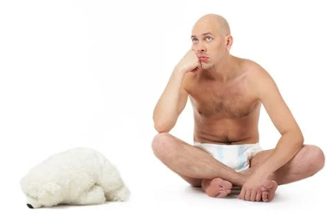 A man sitting in diaper at a teddy bear Stock Photos