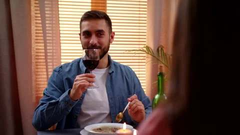 Man Sitting At Dining Table At Home With Woman Drinking Wine Making Toast Video stock 146999359